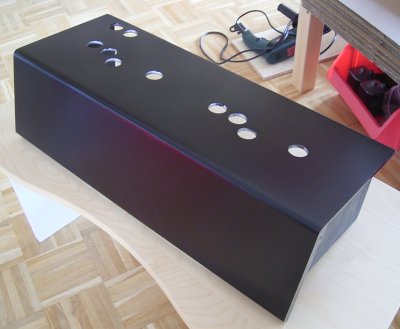 the painted control panel with holes for the buttons and joysticks
